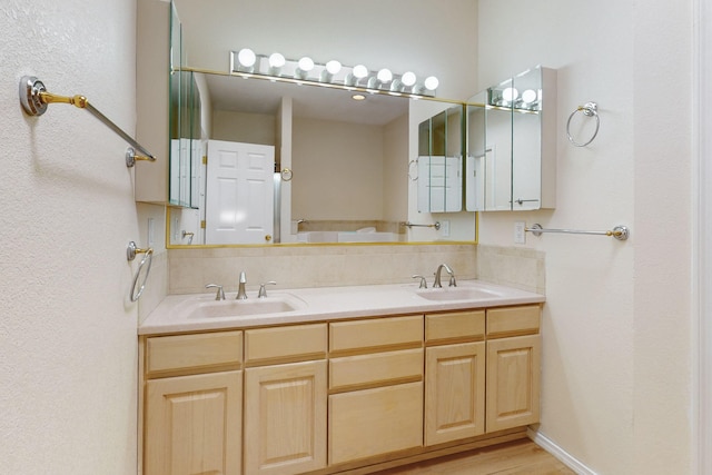 588 Eastlake Dr SE, Rio Rancho, NM 87124 - bathroom featuring double vanity, wood finished floors, backsplash, and a sink
