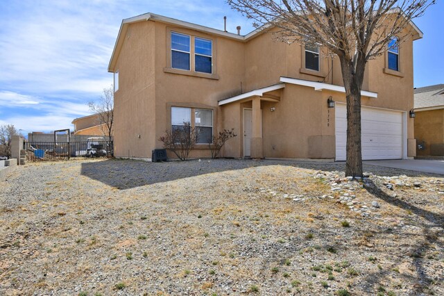 5750 Quay St, Rio Rancho, NM 87144 - view of front of property with stucco siding, concrete driveway, an attached garage, and fence