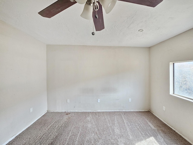 unfurnished room with carpet floors, a textured ceiling, a ceiling fan, and baseboards