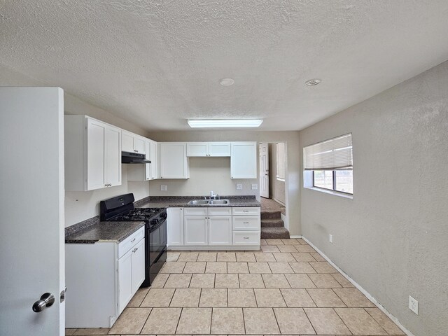 kitchen with a sink, dark countertops, white cabinetry, black range with gas cooktop, and under cabinet range hood
