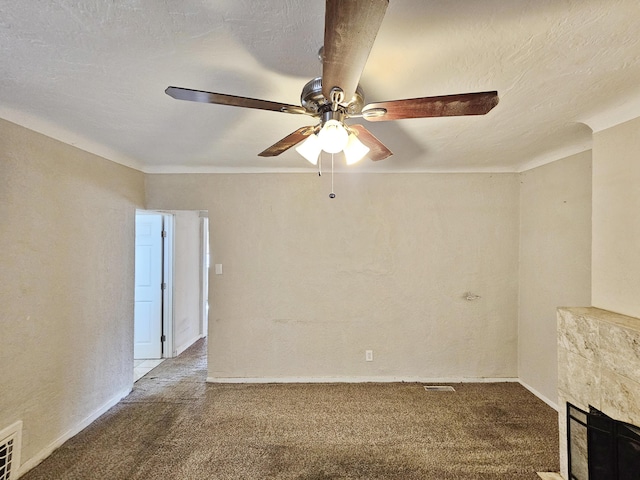 unfurnished living room featuring a ceiling fan, carpet flooring, and a premium fireplace