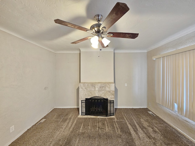 unfurnished living room with ceiling fan, carpet floors, a tile fireplace, baseboards, and visible vents