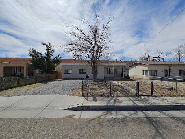 view of front of property featuring stucco siding, a gate, and a fenced front yard