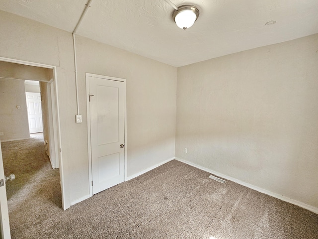 unfurnished room with baseboards and carpet flooring