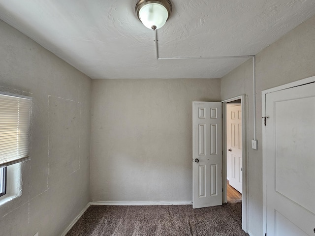 carpeted spare room featuring baseboards