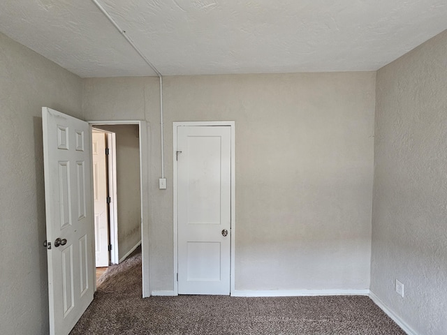 spare room with baseboards and carpet