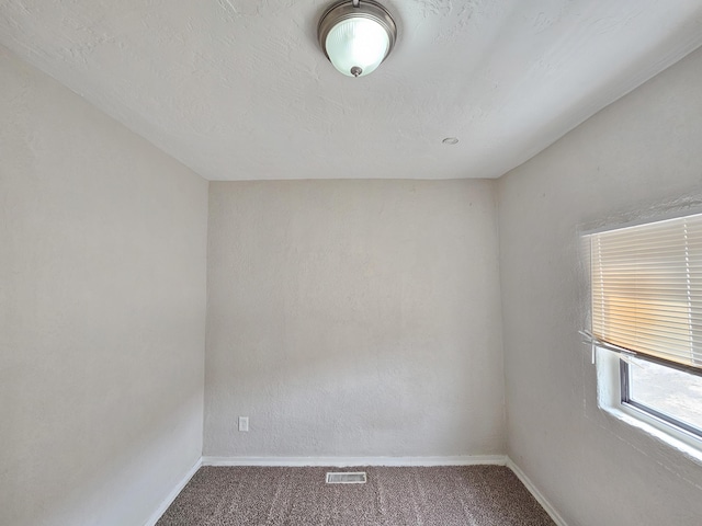 carpeted empty room with baseboards and visible vents