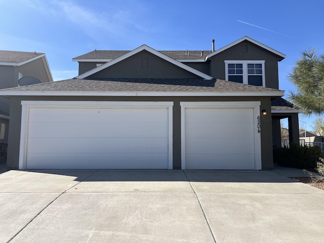 6204 Corte Alzira NW, Albuquerque, NM 87114 - view of front of home featuring concrete driveway, roof with shingles, stucco siding, and an attached garage