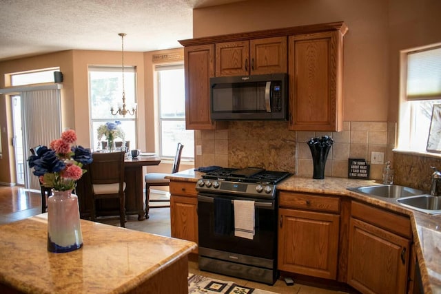 kitchen featuring brown cabinetry, appliances with stainless steel finishes, and a healthy amount of sunlight