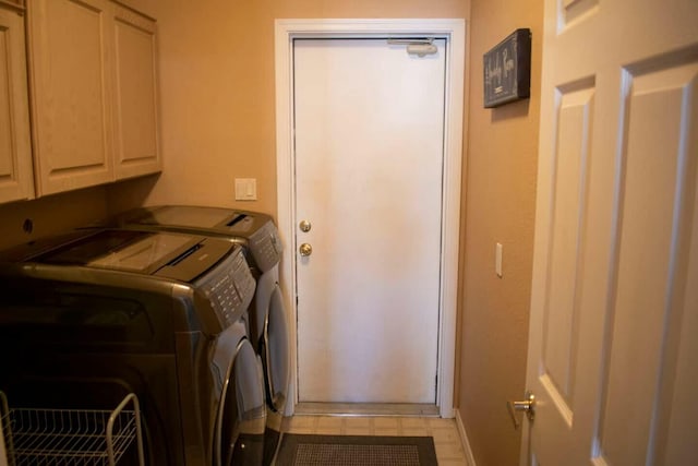 washroom featuring cabinet space, baseboards, and washer and clothes dryer
