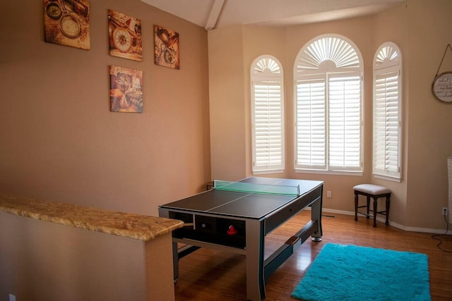 recreation room featuring baseboards and wood finished floors