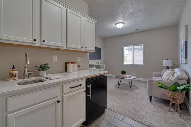 1954 Castle Peak Loop NE, Rio Rancho, NM 87144 - kitchen featuring refrigerator, white cabinetry, a textured ceiling, light carpet, and light stone countertops