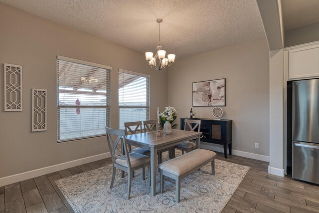 1954 Castle Peak Loop NE, Rio Rancho, NM 87144 - dining space with a chandelier, dark wood-type flooring, and a textured ceiling