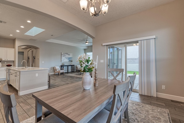 1954 Castle Peak Loop NE, Rio Rancho, NM 87144 - dining room with arched walkways, wood finish floors, a textured ceiling, a ceiling fan, and recessed lighting