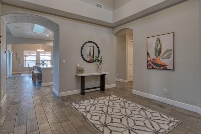 1954 Castle Peak Loop NE, Rio Rancho, NM 87144 - hallway featuring arched walkways, wood finished floors, and a chandelier
