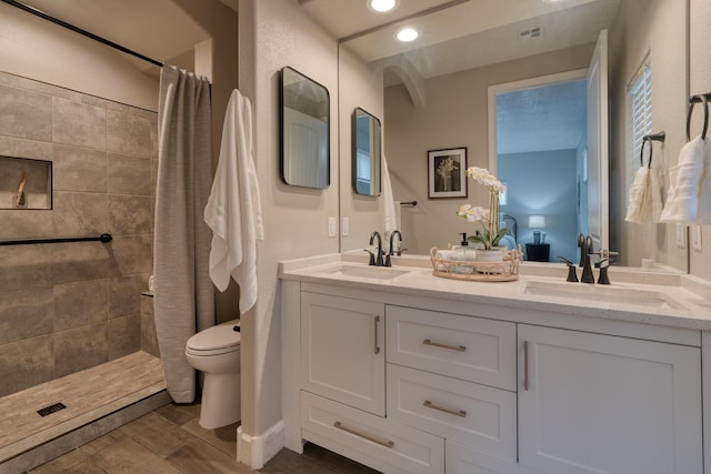 1954 Castle Peak Loop NE, Rio Rancho, NM 87144 - bathroom with double vanity, tiled shower, wood finished floors, and recessed lighting