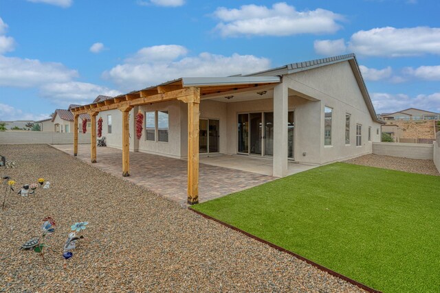 1954 Castle Peak Loop NE, Rio Rancho, NM 87144 - back of house featuring stucco siding, a fenced backyard, and a patio