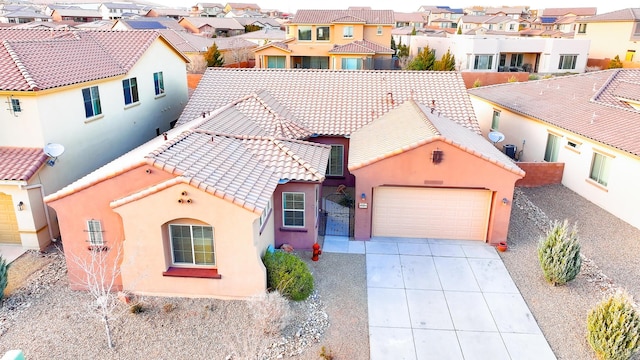 view of front of house featuring stucco siding, concrete driveway, a tiled roof, and a residential view