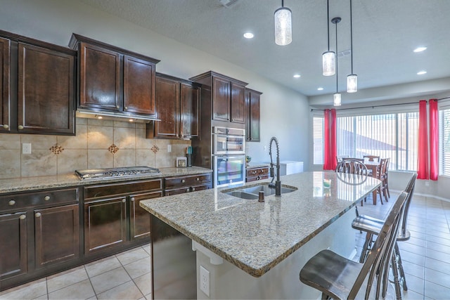 kitchen with light tile patterned floors, light stone counters, recessed lighting, and appliances with stainless steel finishes