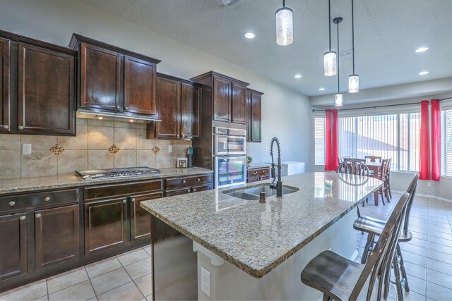 4010 Plaza Colina Ln NE, Rio Rancho, NM 87124 - kitchen with a sink, stainless steel appliances, light tile patterned floors, light stone countertops, and recessed lighting