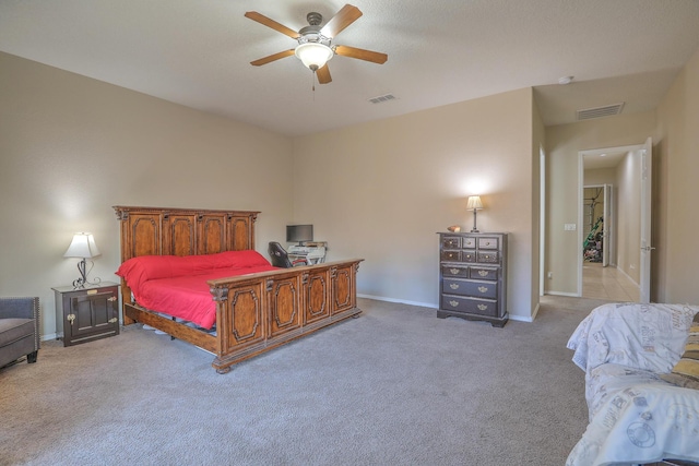 carpeted bedroom featuring baseboards, a ceiling fan, and visible vents