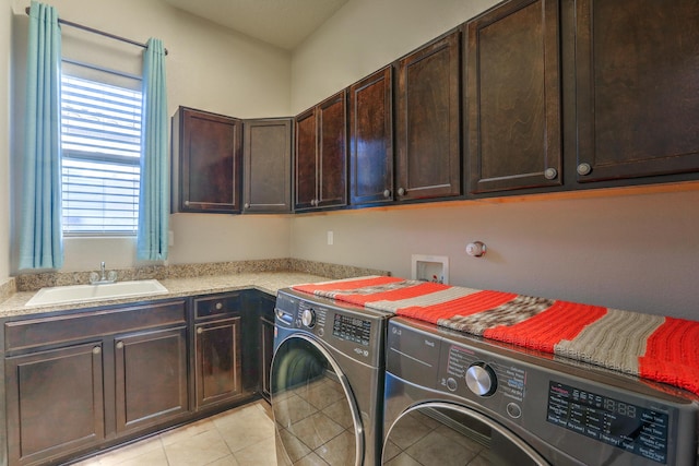 laundry room with light tile patterned flooring, independent washer and dryer, a sink, and cabinet space