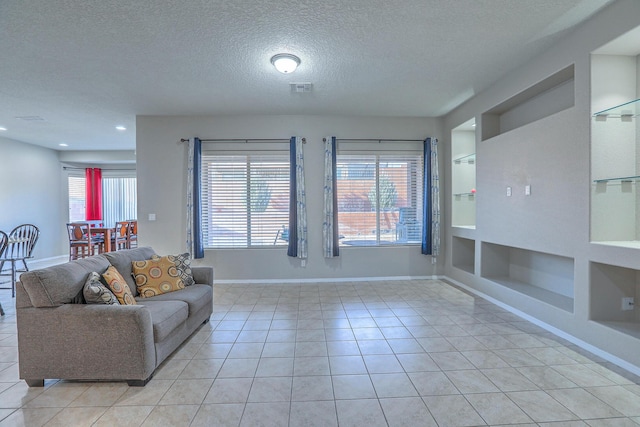 living room featuring baseboards, light tile patterned flooring, built in features, and a textured ceiling