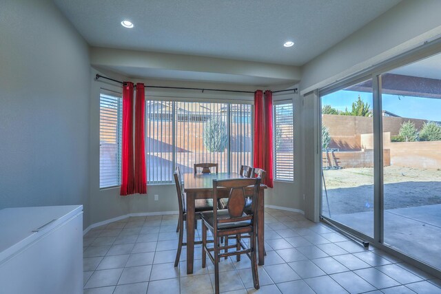 dining space featuring light tile patterned flooring, recessed lighting, and baseboards