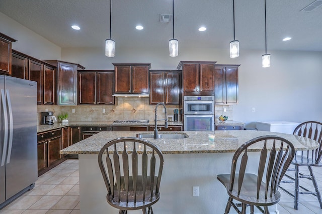 kitchen featuring stainless steel appliances, visible vents, a sink, and light tile patterned floors