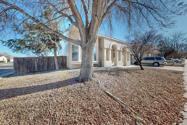 view of front of property with stucco siding and fence