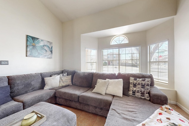 living room featuring light wood-style flooring, baseboards, and lofted ceiling