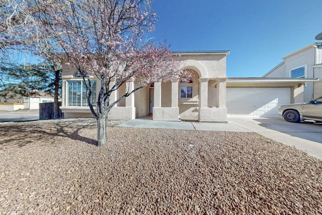 view of front of home featuring stucco siding, an attached garage, and driveway