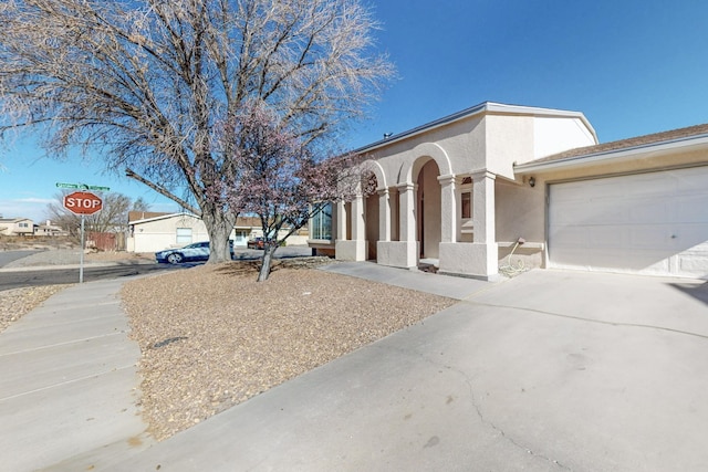 view of front of house with stucco siding, a garage, and concrete driveway