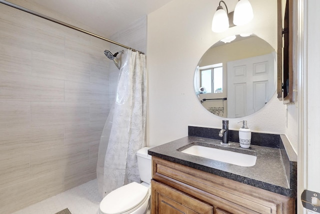 bathroom with toilet, vanity, and tiled shower