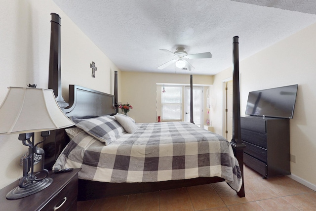 bedroom with a ceiling fan, light tile patterned floors, and a textured ceiling