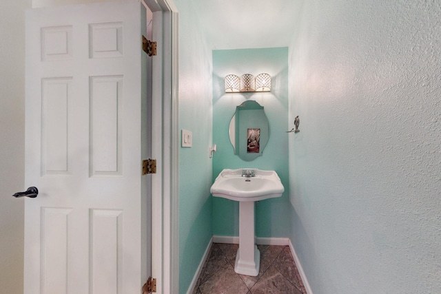 bathroom with baseboards and tile patterned flooring