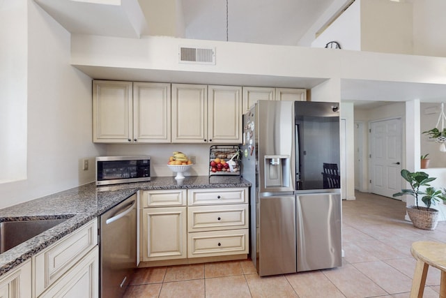 kitchen with cream cabinets, visible vents, light tile patterned floors, and appliances with stainless steel finishes