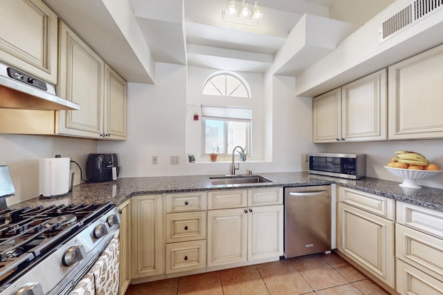 kitchen with light tile patterned flooring, visible vents, cream cabinetry, appliances with stainless steel finishes, and a sink