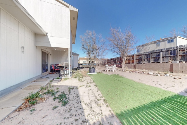 view of yard featuring fence and a patio