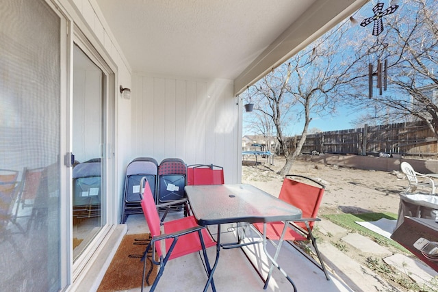 view of patio featuring a trampoline, a fenced backyard, and outdoor dining space
