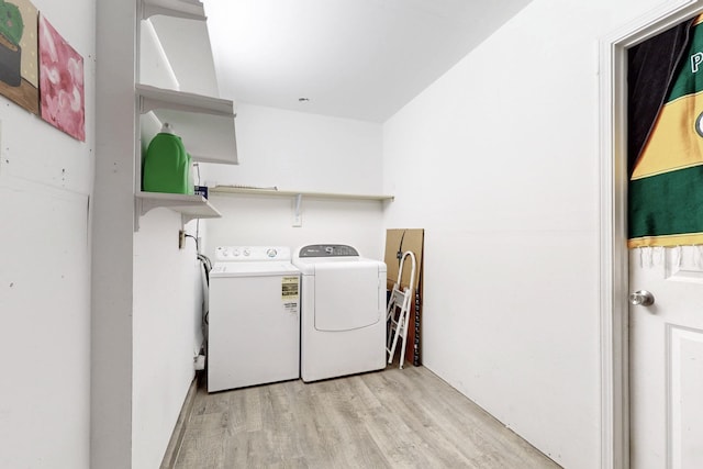 washroom featuring separate washer and dryer, light wood-style floors, and laundry area
