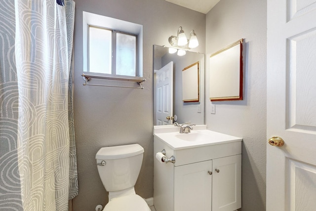 bathroom featuring toilet, a shower with shower curtain, and vanity