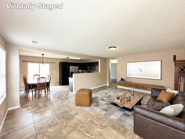 131 Las Ramblas Ave NW, Rio Rancho, NM 87144 - living area featuring a textured ceiling and baseboards
