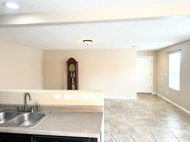 131 Las Ramblas Ave NW, Rio Rancho, NM 87144 - kitchen with a sink, a textured ceiling, light countertops, and baseboards