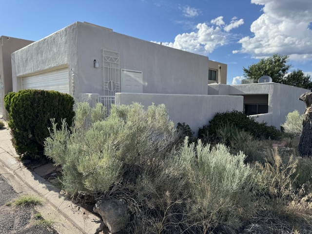 6488 Tahawash St, Cochiti Lake, NM 87083 - view of property exterior with stucco siding and a garage