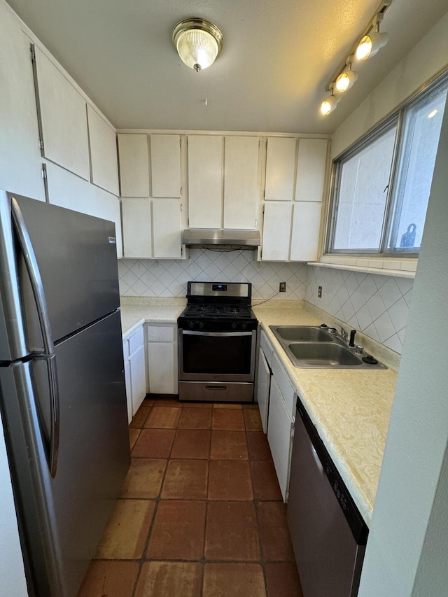 6488 Tahawash St, Cochiti Lake, NM 87083 - kitchen with light countertops, a sink, appliances with stainless steel finishes, under cabinet range hood, and decorative backsplash