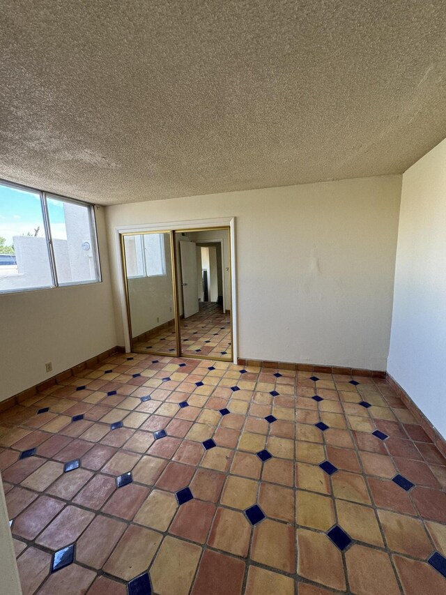 6488 Tahawash St, Cochiti Lake, NM 87083 - tiled spare room with baseboards and a textured ceiling