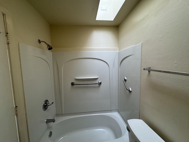 6488 Tahawash St, Cochiti Lake, NM 87083 - bathroom with a textured wall, toilet, shower / bath combination, and a skylight