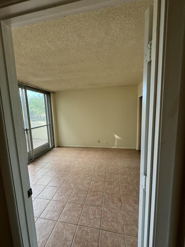 6488 Tahawash St, Cochiti Lake, NM 87083 - empty room with light tile patterned flooring, baseboards, and a textured ceiling