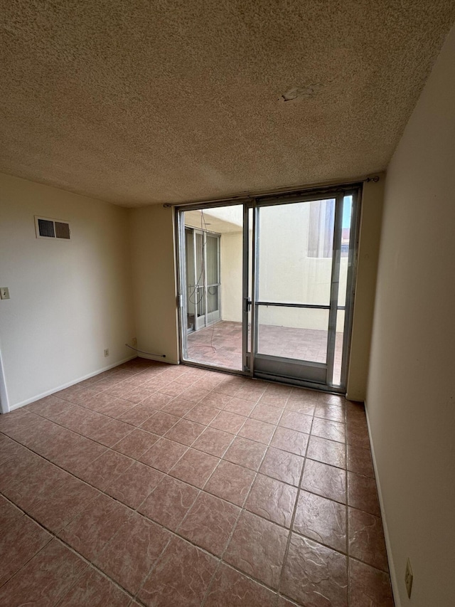 6488 Tahawash St, Cochiti Lake, NM 87083 - tiled empty room featuring baseboards, visible vents, expansive windows, and a textured ceiling